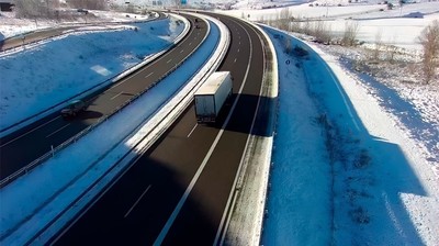 Camión circulando por carretera nevada