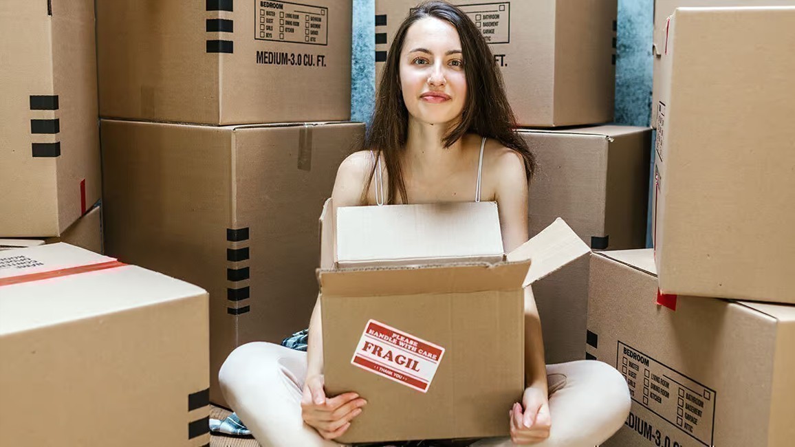 Joven de mudanza entre cajas