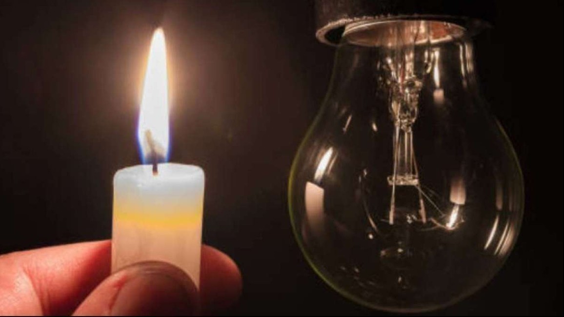 Vela encendida y bombilla apagada