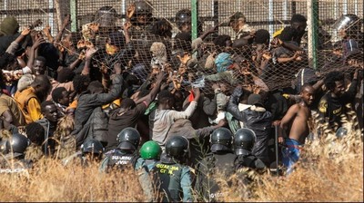 Emigrantes saltando la valla