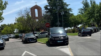 Coches mal aparcados junto a la parroquia de Caná